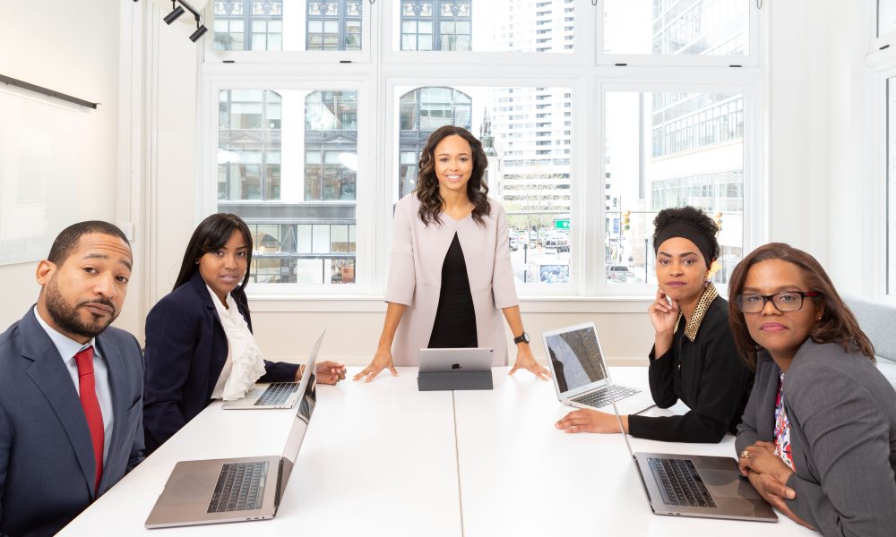 Woman standing on the center table with four people on the side
