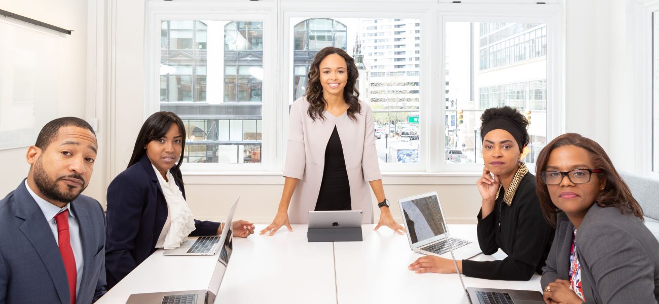 Woman standing on the center table with four people on the side