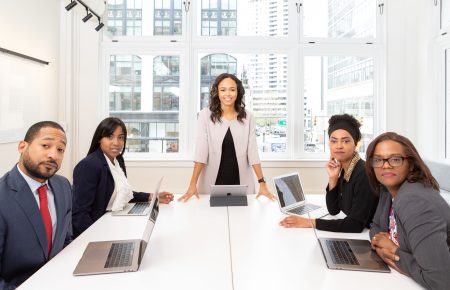 Woman standing on the center table with four people on the side