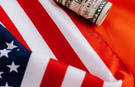 bright american flag with roll of greenbacks