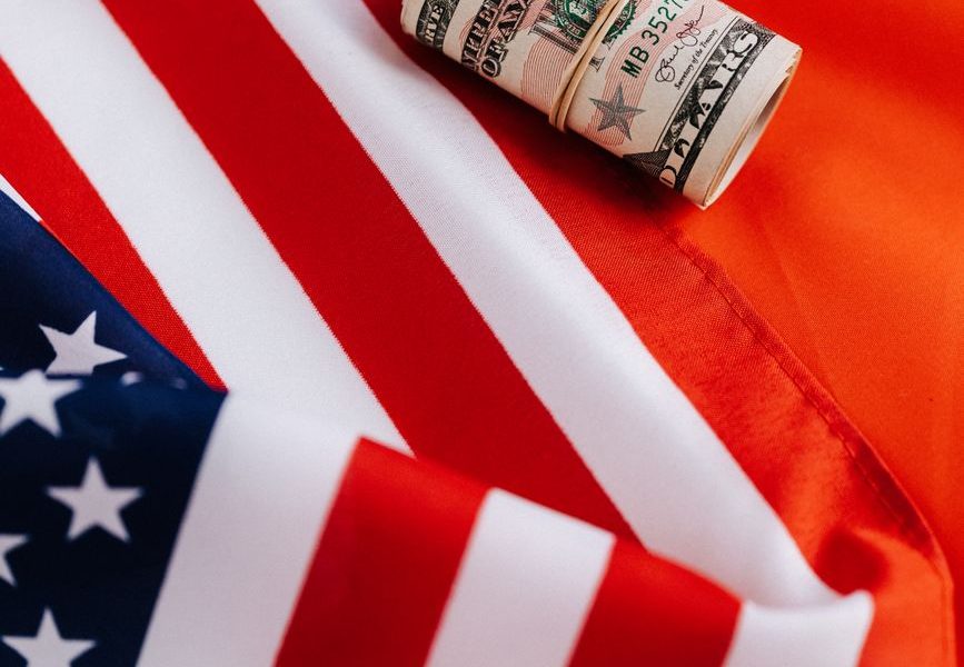 bright american flag with roll of greenbacks